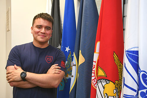 Robert Charles standing next to military flags