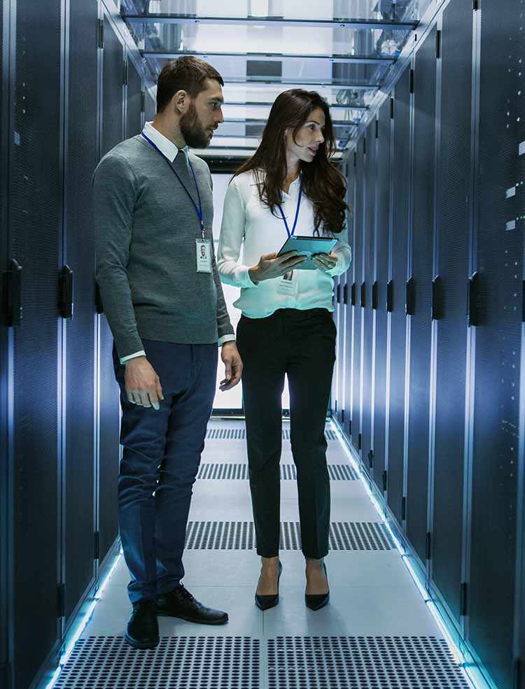 Man and woman looking at computer equipment.
